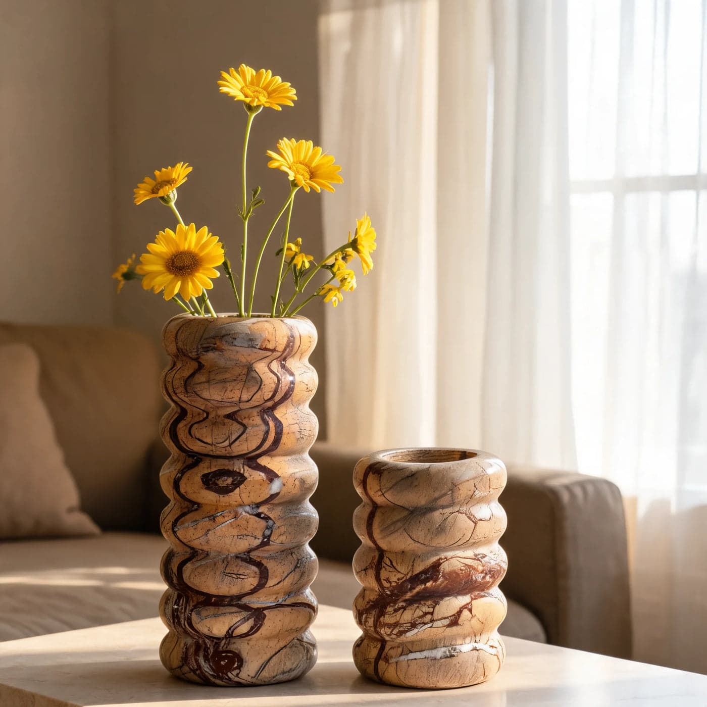 JAY rainforest marble vessels with yellow flowers on a sunlit table