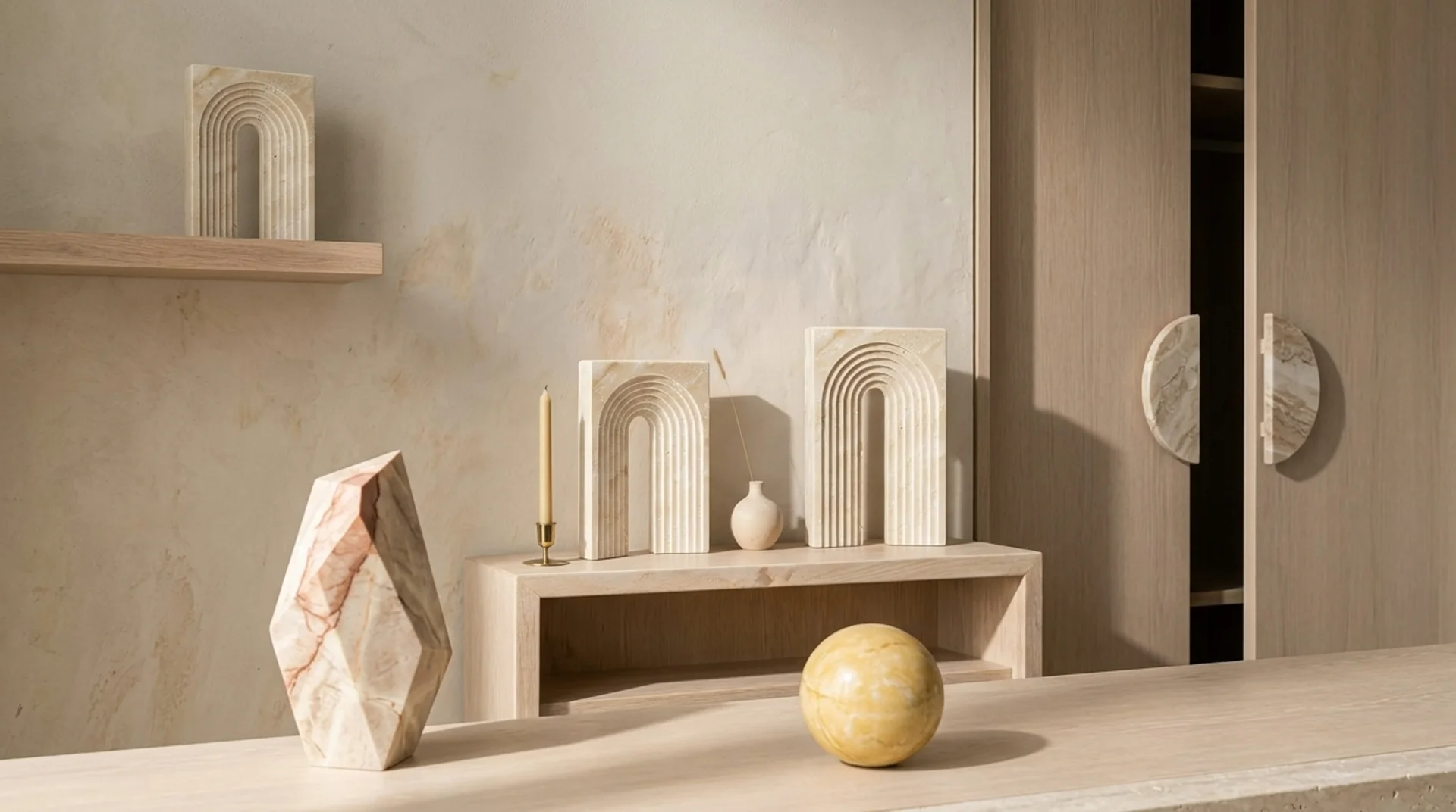 Athina travertine arch ornaments in three scales on a wooden shelf